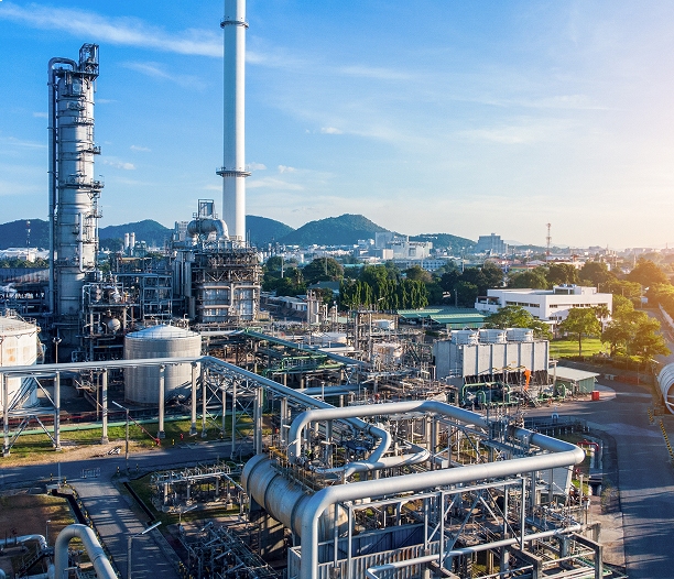 Complexe industriel avec colonnes de distillation, réservoirs et réseaux de tuyauterie