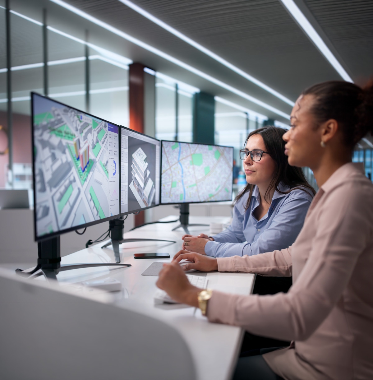 Collaboratrices travaillant sur des modèles d'architecture 3D dans un bureau moderne